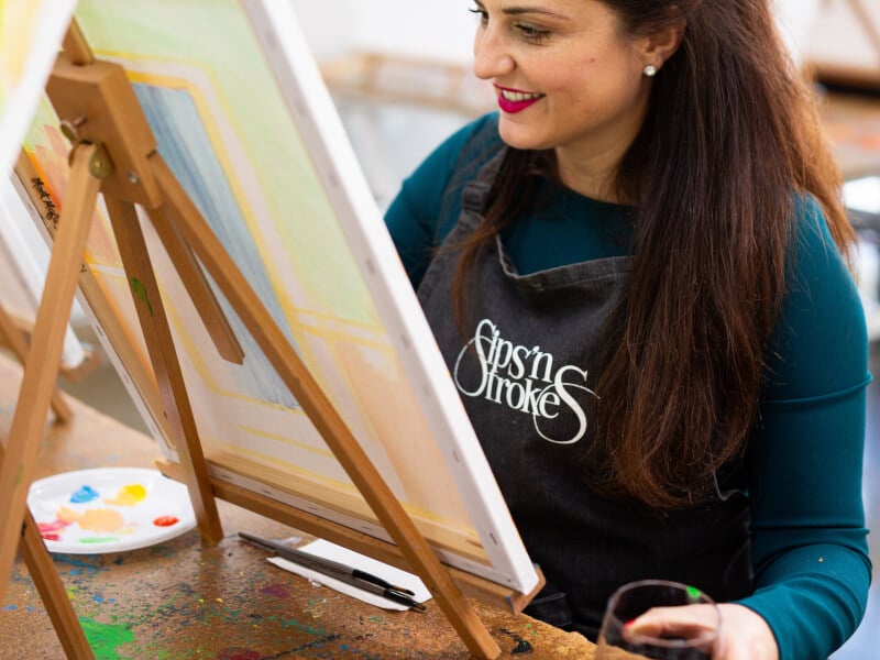 woman smiling and painting
